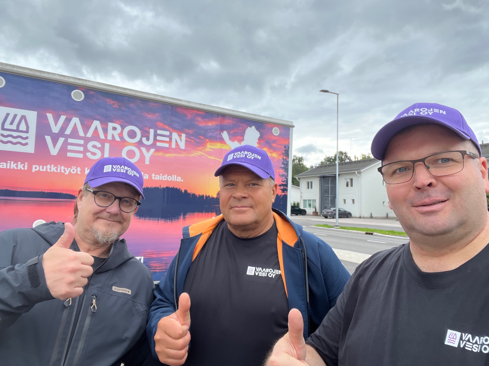 Vaarojen Veden tiimi yrityksen perävaunun edessä